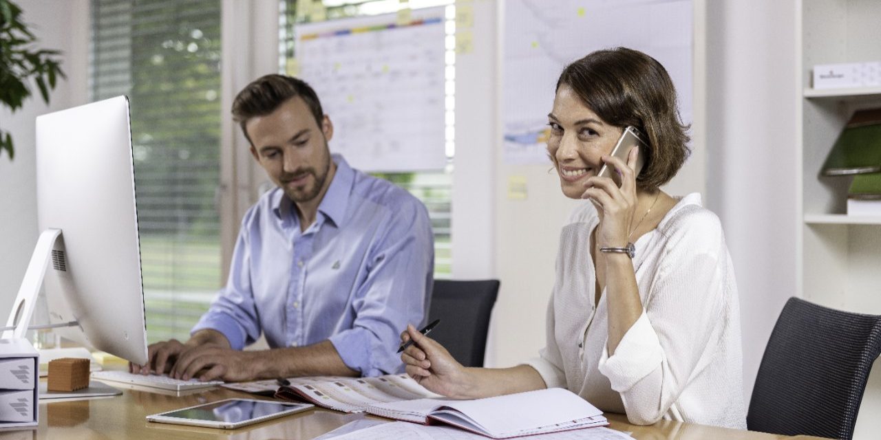 Male and female project manager collaborating in front of computer screen at office